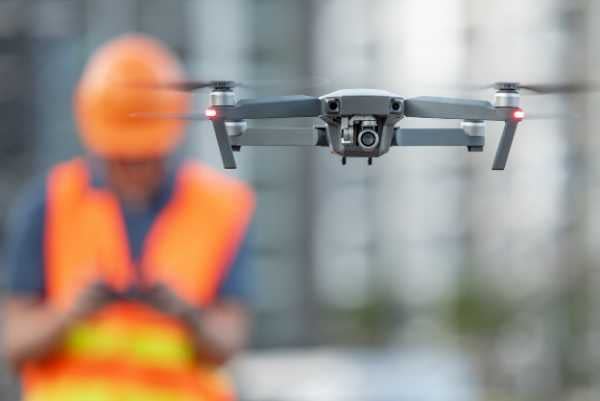 a construction worker piloting a drone remotely
